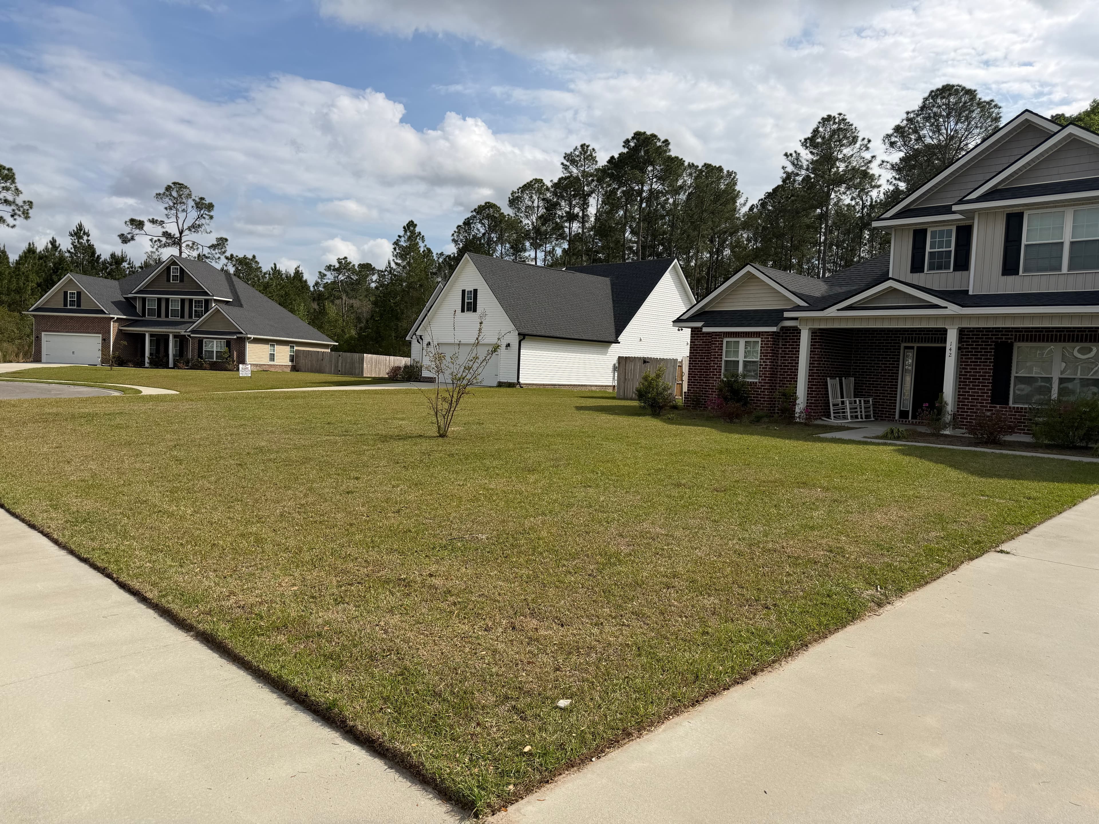 Wide neighborhood lawn professionally maintained by A&P Lawn Care in Liberty County, GA